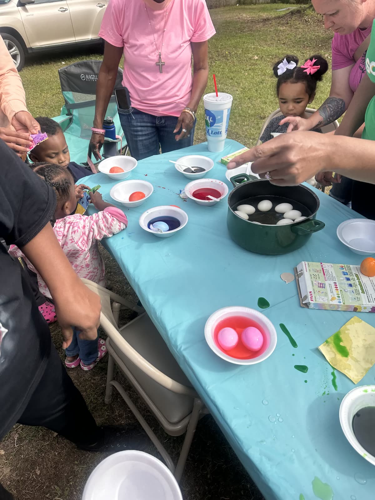 Children coloring eggs during an outdoor spring activity